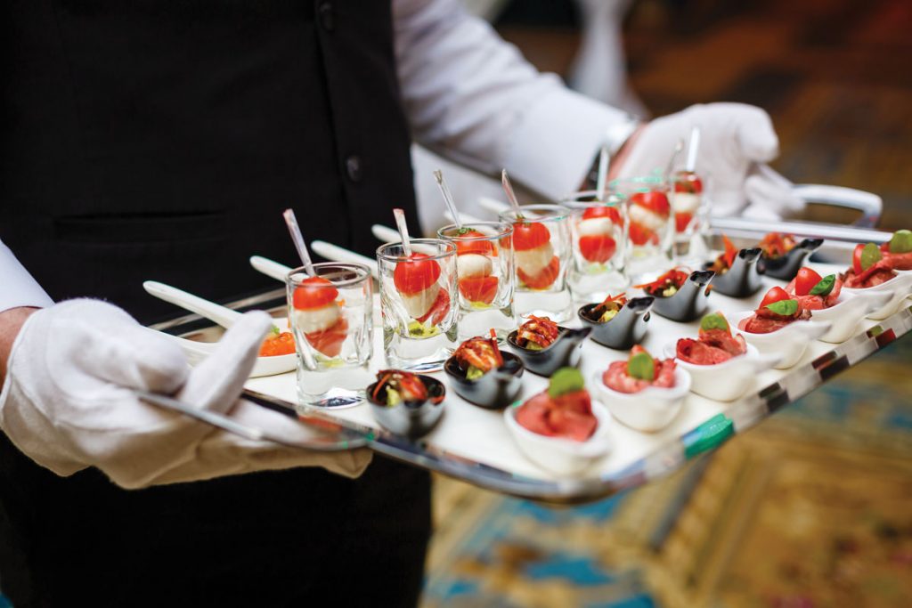 Server holding a tray of appetizers at a banquet